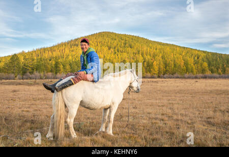 Il mongolo uomo seduto su un cavallo Foto Stock