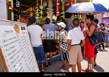 La Seychelles, Mahe, Victoria, India giorno, coda dei clienti al di fuori del paiolo di rame il cibo indiano in stallo Foto Stock