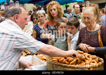 La gente del luogo di acquisto ciambella churro snack in strada nel corso San Fermin Fiesta a Pamplona, Navarra, Spagna settentrionale Foto Stock