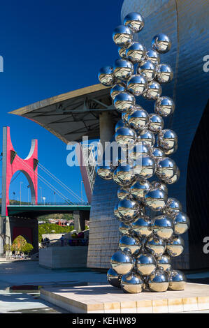 Bomba 1954 presentano da Anish Kapoor di chrome sfere con archi rossi dietro dal Museo Guggenheim a Bilbao, Paesi Baschi Foto Stock