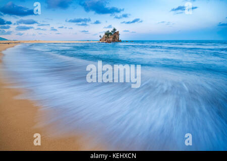 Una lunga esposizione Otturatore lento delle onde durante il tramonto a kemasik beach, terengganu, Malaysia Foto Stock