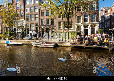 Amsterdam, Paesi Bassi - 23 agosto 2017: alcune persone sono a riposo in estate cafe sul greto del fiume a giornata di sole Foto Stock