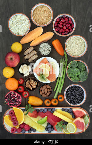Health food per cuore il concetto di fitness con superfoods di pesce frutta e verdura, semi, noci, cereali, cereali, erbe e spezie Foto Stock