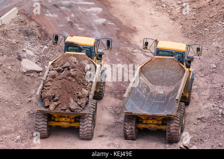 Sterri industriale il caricamento di autocarri pesanti su rocce costruzione sito foto aeree. Foto Stock