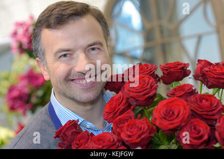 L'uomo tenendo un mazzo di rose Foto Stock