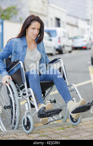 Donna disabile provando duro a spostarsi in città Foto Stock