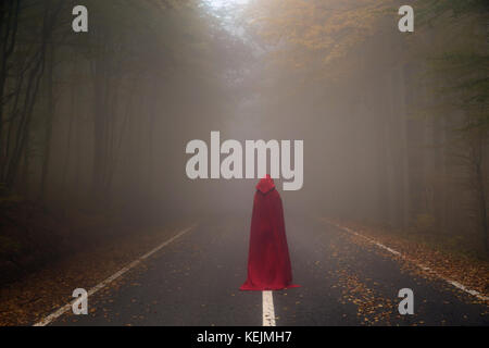 Red Riding Hood ritratto in autunno la foresta di nebbia Foto Stock