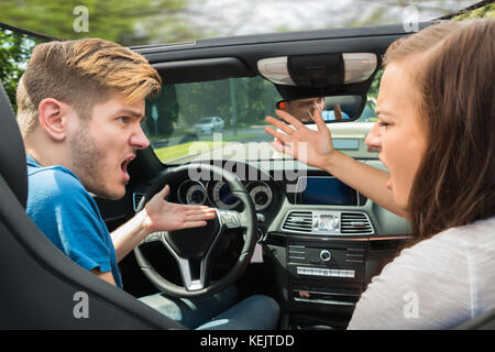 Infelice coppia giovane quarreling in auto Foto Stock