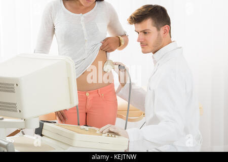 Close-up di una donna ricevendo ultrasuoni dello stomaco dal medico in ospedale Foto Stock