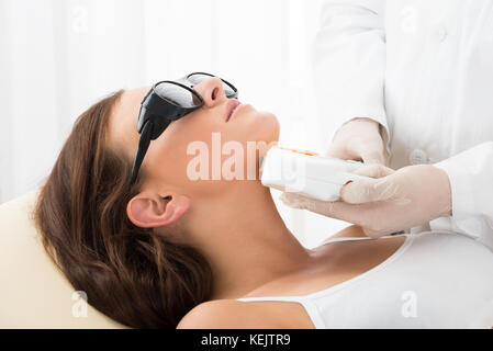 Close-up di un terapeuta dando di epilazione laser Trattamento sulle donne il collo Foto Stock