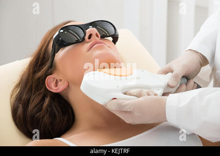 Close-up di un terapeuta dando di epilazione laser Trattamento sulle donne il collo Foto Stock