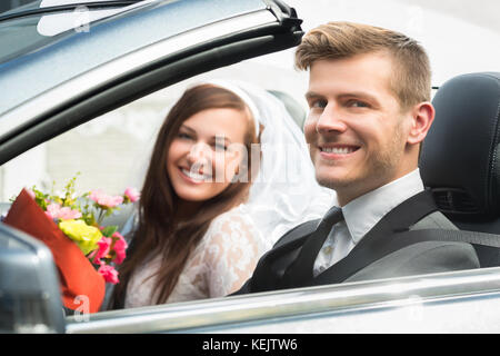 Ritratto di giovane appena una coppia sposata in auto Foto Stock