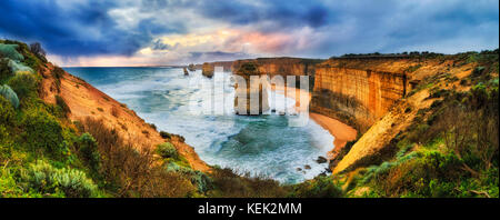 Stormy colorato tramonto oltre dodici apostoli marine park sulla Great Ocean Road da belvedere verso la pietra calcarea erosa permanente apostolo rocce. Foto Stock