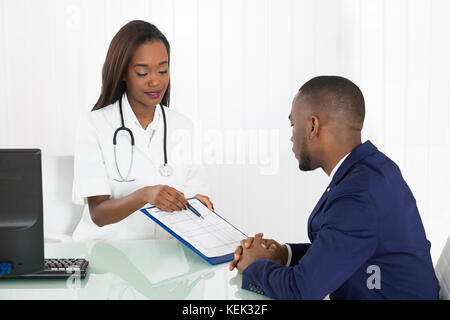 Medico donna offrendo consulenza medica di un paziente giovane Foto Stock