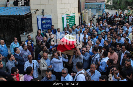 Le persone trasportano la bara dell'ufficiale di polizia egiziano, Ahmed Fayez, ucciso il giorno prima in una sparatoria con sospetti militanti a sud-ovest del Cairo, durante la processione funebre alla Moschea El Hosary nella città del sesto ottobre, a 15 km dal Cairo, Egitto, 21 ottobre 2017. Secondo il Ministero degli interni egiziano, 16 agenti di polizia sono stati uccisi e 13 feriti in una sparatoria con sospetti militanti sulla via Cairo-Bahariya Oasis, a sud-ovest del Cairo, dopo che le fonti di sicurezza avevano messo il bilancio delle vittime a 50. Foto: Fayed El-Geziry/DPA/DPA Foto Stock
