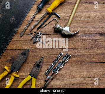 Rusty e vecchia falegnameria utilizzato e garage strumenti in legno marrone chiaro sfondo, che mostra gli strumenti di vario,con pinze in metallo e vide,metalli punte da trapano martello, Foto Stock