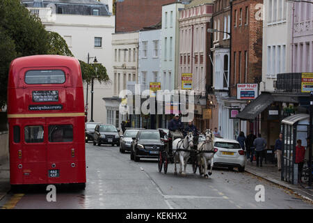 Windsor, Regno Unito. Il 21 ottobre, 2017. un vecchio autobus a due piani e un cavallo e carrozza in Windsor high street. Foto Stock