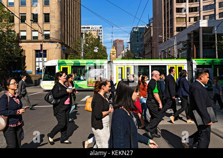 I lavoratori della città attraversando Elizabeth Street in Melbourne Victoria Australia. Foto Stock