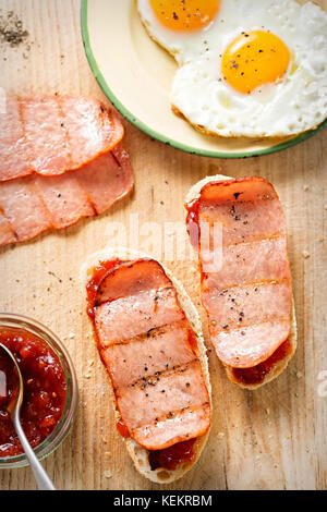 Le fette di pane con il pomodoro relish, Turchia rasher e uovo fritto Foto Stock