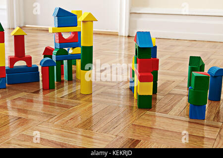 In legno colorato i blocchi di costruzione su pavimento in legno duro. Foto Stock