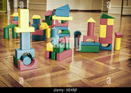 In legno colorato i blocchi di costruzione su pavimento in legno duro. Foto Stock