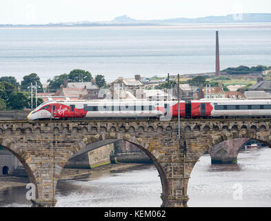 La Vergine Azuma treno attraversa Royal ponte di frontiera a Berwick upon Tweed in viaggio verso nord sul suo primo viaggio in Scozia. Foto Stock