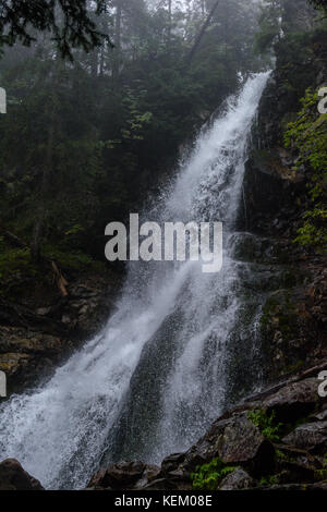 Grande Cascata dal burrone in autunno, nel fiume di montagna con rocce e percorsi turistici scale Foto Stock