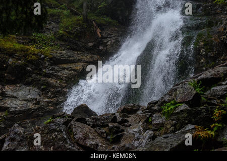 Grande Cascata dal burrone in autunno, nel fiume di montagna con rocce e percorsi turistici scale Foto Stock