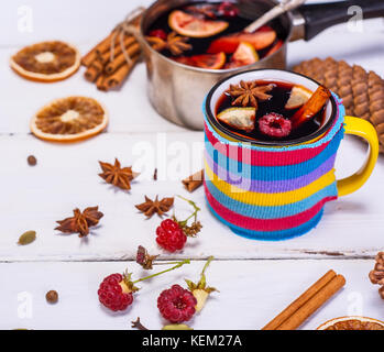 Vin brulé in una tazza e gli ingredienti per la preparazione di alcool su un bianco tavolo in legno Foto Stock