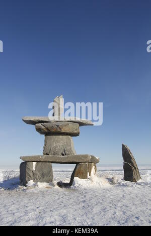 Inukshuk (Inuksuk) trovata vicino a Churchill, Manitoba con neve sul terreno all inizio di novembre in Canada Foto Stock