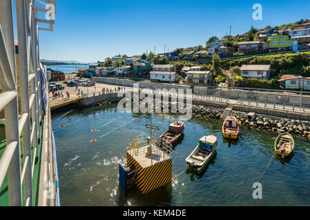 Imbarcazioni al molo e case in Puerto Aguirre, vista da una nave traghetto, a Isla Las Huichas, Islas Huichas arcipelago, Patagonia, Cile Foto Stock