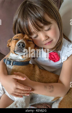 Un bambino ragazza e il pet con gli occhi chiusi Foto Stock