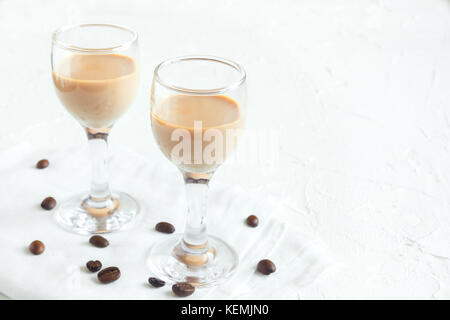 Irish cream di liquore al caffè e caffè in chicchi di colore bianco su sfondo di legno - festa in casa di panna da caffè drink alcolici Foto Stock