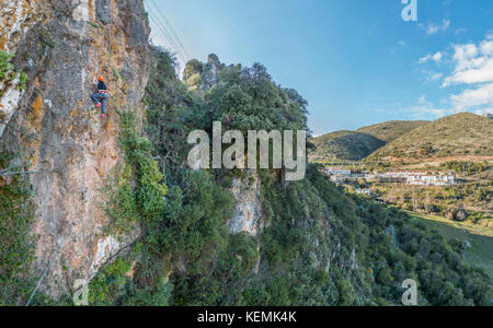 Irriconoscibile donna turistica a scalare una via ferrata sulla montagna in giornata di sole Foto Stock