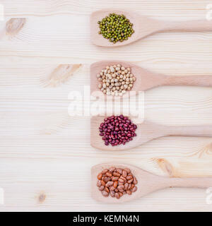 Assortimento di fagioli e lenticchie in cucchiaio di legno su sfondo di legno. semi di soia, Mung bean , Fagiolo rosso e marrone fagioli pinto . Foto Stock