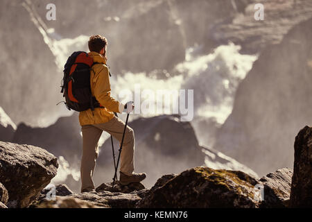 Escursionista escursionismo con zaino guardando a cascata Foto Stock