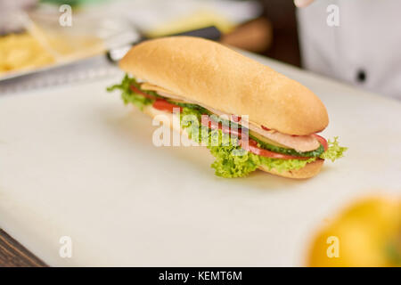 Fresh hot dog su scheda bianca. lungo sandwich con verdure fresche e salsiccia. la cottura e il concetto di cibo. Foto Stock