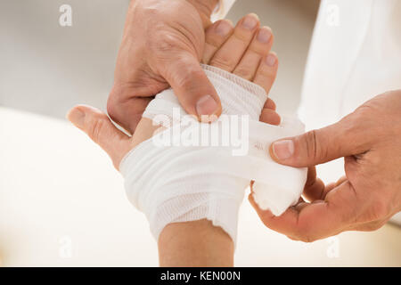 Close-up di persona a mano bendaggio di incarto per il paziente Foto Stock