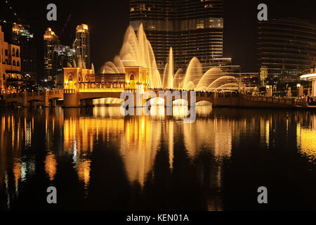 Fontana di dubai visualizza, scattata di notte nel centro cittadino di Dubai, Emirati arabi uniti. La foto è in colori contrastanti - oro e nero. Foto Stock