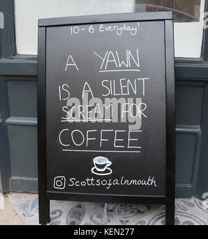 Scheda pubblicitari al di fuori di un coffee shop in Alnmouth, Northumberland, Regno Unito dichiarando uno sbadiglio è un silent scream per caffè Foto Stock