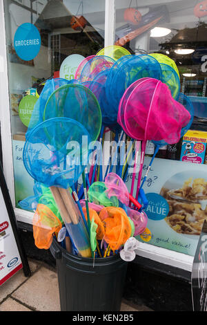 Un display a colori di bambini le reti da pesca per la vendita al di fuori di un negozio di Alnmouth, Northumberland, Regno Unito Foto Stock