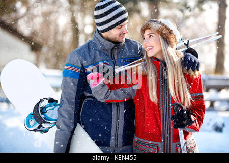 Sciatore maschio abbracciando la sua fidanzata outdoor sulla neve Foto Stock