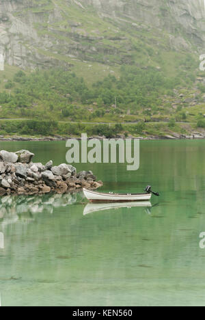 La barca e le pittoresche rocce sono riflesse in acqua chiara, arcipelago delle Lofoten, nordland county, Norvegia. nazionale percorso turistico lofoten Foto Stock