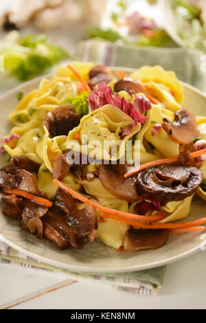 Tortellini di grandi dimensioni con funghi e radicchio rosso - primo piano Foto Stock