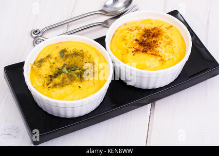 Due ciotole con fatti in casa hummus sul bianco sullo sfondo di legno. studio foto Foto Stock