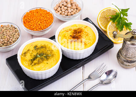 Due ciotole con fatti in casa hummus sul bianco sullo sfondo di legno. studio foto Foto Stock