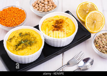 Due ciotole con fatti in casa hummus sul bianco sullo sfondo di legno. studio foto Foto Stock