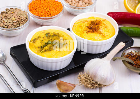 Due ciotole con fatti in casa hummus sul bianco sullo sfondo di legno. studio foto Foto Stock