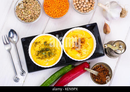 Due ciotole con fatti in casa hummus sul bianco sullo sfondo di legno. studio foto Foto Stock