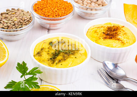 Due ciotole con fatti in casa hummus sul bianco sullo sfondo di legno. studio foto Foto Stock